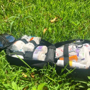 A bag of medical supplies in the grass.