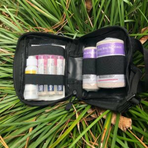 A bag filled with medical supplies laying in the grass.