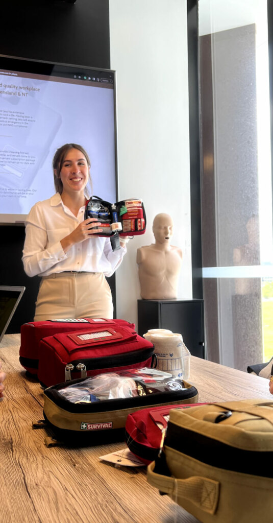 First aid instructor presenting emergency equipment during a training session.